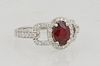 Lady's 14K White Gold Dinner Ring, with an oval 1.15 carat ruby a top a border of round diamonds, with pierced diamond mounted lugs,...