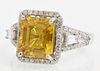 Lady's 14K White Gold Dinner Ring, with a 5.33 carat cushion cut yellow sapphire atop a border of pave diamonds, the pave diamond mo...