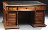 French Henri II Style Carved Walnut Desk, c. 1880, the stepped rectangular top with a leather insert writing surface over a center d...