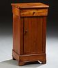 French Louis Philippe Cherry Nightstand, c. 1880, the rounded corner top above a frieze drawer and a long cabinet door enclosing two...