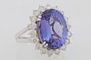 Lady's Platinum Dinner ring, with a 10.78 carat oval tanzanite atop a border of round diamonds, on a split sided band, size 7, with...