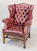 Tufted leather wing chair having brass rivets, ht. 43", wd. 35".