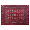 Tapete. Pakistán. Siglo XX. Estilo Boukhara. Elaborado en fibras de lana y algodón. Decorado con sobre fondo rojo.