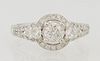 Lady's 14K White Gold Dinner Ring, with a central .53 carat round diamond atop a border of small round diamonds, flanked by diamond...