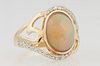 Lady's 14K Yellow Gold Dinner Ring, with an oval cabochon 2.74 ct. opal, on a pierced bypass band mounted with edge diamonds, total diamond wt.- .27 c