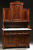 American Carved Walnut Marble Top Sideboard, 19th c., the arched crest over a large arched panel cupboard door, flanked by reeded pilasters and setbac
