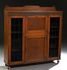 English Carved Oak Leaded Glass Secretary Bookcase, c. 1930, with a central drop front desk with a fitted interior, over a frieze drawer and a cupboar