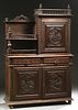 French Provincial Henri II Style Carved Oak Buffet a Deux Corps, c. 1880, Brittany, the spindled crown over a figural carved cupboard door right with 