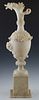 Carved Alabaster Ewer Form Vase, early 20th c., probably Italian, with a figural spout over floral relief decorated sides, to a knopped socle support,