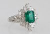 Lady's Platinum Dinner Ring, with a 1.9 carat emerald, flanked on all sides by baguette diamonds and bands of small round diamonds, the split tapering