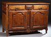 French Louis XV Style Carved Walnut Sideboard, c. 1820, the rounded edge and corner plank top above three frieze drawers over arched fielded panel cup