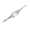 Prendedor con perla y diamantes en oro blanco de 10k. 1 perla color crema de 9 mm. 24 diamantes corte 8 x 8. Peso: 6.8 g.