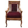 Armchair, Early 20th century, Carved wood decorated with plant motifs and wine-colored upholstery.