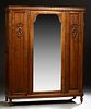 French Louis XVI Style Carved Walnut Armoire, c. 1900, the leaf carved crown over an arched wide beveled mirror door, flanked by nar...