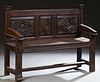French Provincial Renaissance Style Carved Oak Bench, 19th c., the back with three carved panels, over a two board seat and sloping...