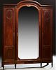French Louis XVI Style Carved Mahogany Armoire, c. 1900, the stepped arched crown over a large arched beveled mirror door, flanked b...