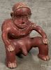 Pre-Columbian Colima ceramic figure of a seated hunchback man with a red slip finish