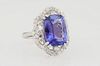 Lady's 14K White Gold Dinner Ring, with a 7.47 ct. cushion cut tanzanite, atop a pierced scalloped diamond mounted border, total diamond wt.- .98 cts.