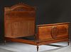 French Louis XVI Carved Walnut Double Bed, early 20th c., the arched floral carved headboard joined by wooden rails and a fielded panel footboard with