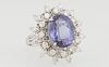 Lady's 14 K White Gold Dinner Ring, with an oval 7.52 ct. tanzanite, atop a border of round diamond "points" on a split shoulder band, total diamond w
