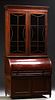 English Carved Mahogany Secretary Bookcase, 19th c., the stepped crown over double mullioned glazed doors, above a cylinder desk, opening to a birds e