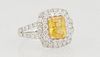 Lady's Platinum Dinner Ring, with a cushion cut 2.09 yellow sapphire, atop a conforming double graduated concentric border of round diamonds, the spli