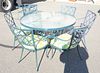 Eleven piece outdoor lot to include round glass top table, six chairs, a loveseat, and three tables.