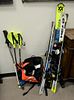 Group of children's snow skis, boots, helmets and poles, sizes vary.