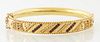 English Victorian 9K Yellow Gold Hinged Bangle Bracelet, c. 1900, with three diagonal rows of small round garnets separated by four ...