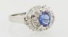 Lady's Platinum Dinner Ring, with a central 1.01 oval sapphire, atop a spiral border mounted with baguette and round diamonds, total...