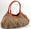 Gucci Burnt Umber Leather and Beige Monogramed Canvas D-Ring Hobo Handbag, the exterior with gold hardware, opening to a brown lined...