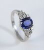 Platinum Ring 
set with center oval blue stone, flanked by six diamonds on either side
size 6