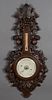 French Black Forest Style Carved Oak Barometer, 19th c., the highly carved grape and nut pierced top over an alcohol thermometer and a barometer marke