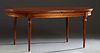 French Louis XVI Style Carved Cherry Dining Table, 20th c., the oval top over a wide skirt, on turned tapered reeded legs, with two semi circular leav