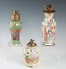 Group of Three Chinese Porcelain Butane Table Lighters, 20th c., of baluster form, one famille rose; one ribbed with landscape decoration, and the thi