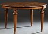 French Carved Walnut Louis XVI Style Dining Table, 20th c., the oval stepped rounded edge top over a wide skirt, on turned tapered reeded legs, openin