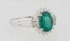 Lady's 18K White Gold Dinner Ring, with an oval 1.19 carat emerald, flanked by baguette diamonds on both sides and diamond mounted points on the top a