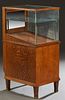Carved Oak Freestanding Pen Display Case, c. 1910, with a glass top and three glass sides, one side with a sliding oak door, on an oak base, on tapere