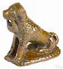 Pennsylvania redware figure of a seated spaniel, 19th c., with a basket clutched in its jaws, 4'' h
