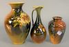 Group of Three Rookwood Pottery Vases
with floral motifs and marked to the underside 
one made by the artist Amelia Brown Sprague
one signed illegibly