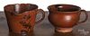 Two Pennsylvania redware handled cups, 19th c., with manganese splotching, one with a spout, 3'' h.