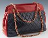 Chanel Black and Red Lambskin Chain Shoulder Bag, with gold tone hardware and zip closure, the interior of the bag lined in red leather with two zip c