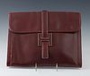 Hermes Burgundy Calfskin Jige Clutch GM Clutch, with a H slip buckle, with an beige canvas lined interior, H.- 10 3/4 in., W.- 13 1/2 in.