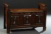 French Empire Style Carved Walnut Hall Bench, 19th c., with rolling pin arms flanking the lifting lid, over a front with three relief carved concentri