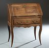 French Louis XV style Carved Walnut Slant Front Secretary, early 20th c., the slant lid opening to an interior fitted with drawers and shelves, over a