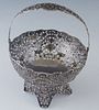 German .800 Silver Handled Basket, late 19th c., the pierced sides with relief floral and scroll decoration, on four splayed like decorated feet, H.- 