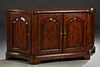 Lloyd Buxton Carved Walnut Four Door Sideboard, late 20th c., the stepped rounded edge curved top over double fielded panel cupboard doors, flanked by