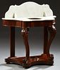 American Carved Mahogany Marble Top Washstand, 19th c., the arched figured white marble splash over a like marble top with a cutout for a bowl, on scr