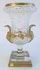 French Crystal and Gilt Bronze Urn, having handles with face masks; on square, gilt, bronze base, height 16 inches.