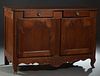 French Provincial Louis XV Style Carved Cherry Sideboard, 19th c., the canted corner rounded edge top over two frieze drawers above double cupboard do
